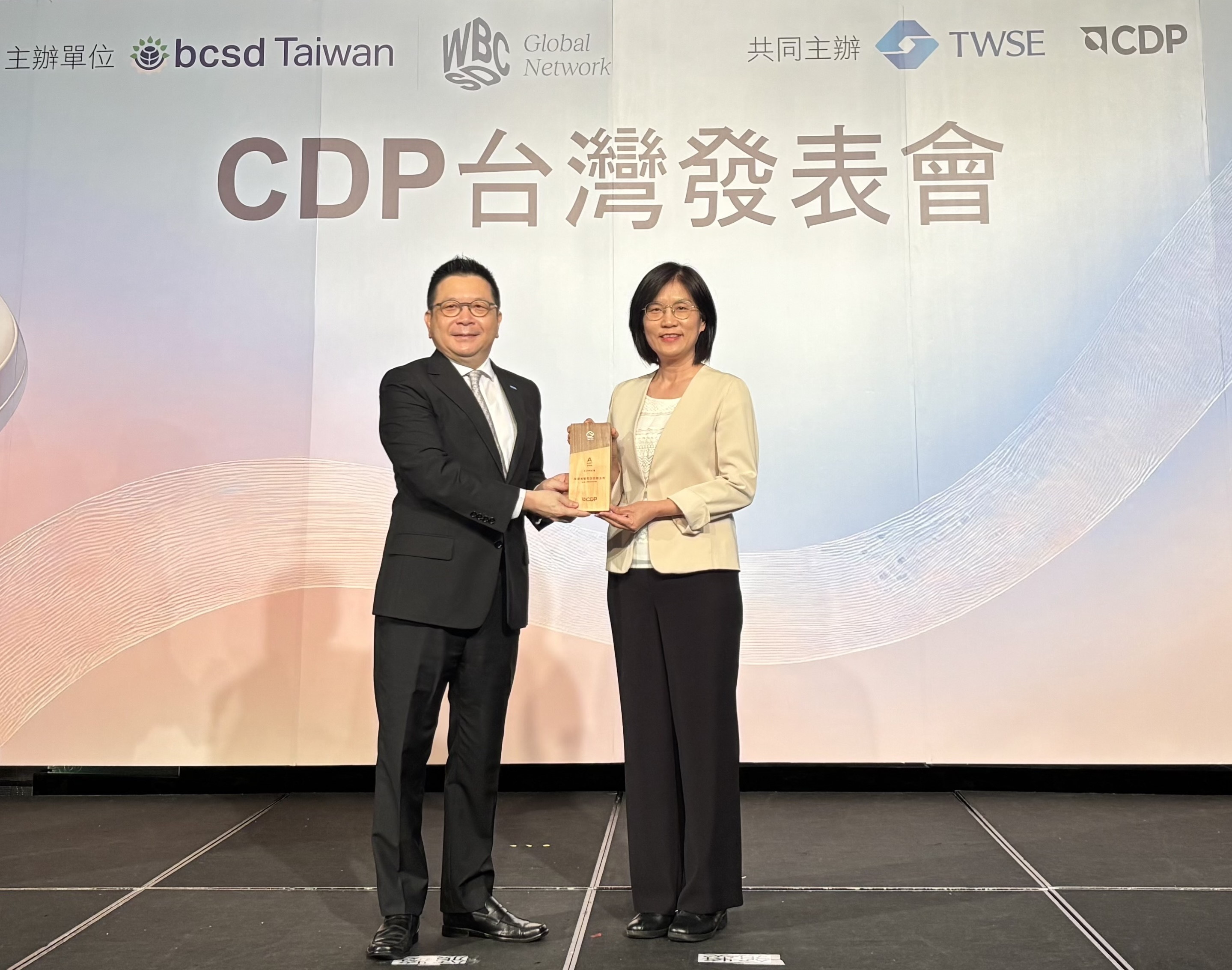 友達永續成果再獲國際評比肯定，獲頒CDP氣候與水資源雙項領導力評級。今由臺灣證券交易所董事長林修銘（左）頒獎，友達光電永續長古秀華（右）代表受獎